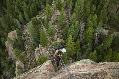 Woman rappels from summit of matron, flatirons near boulder, colorado