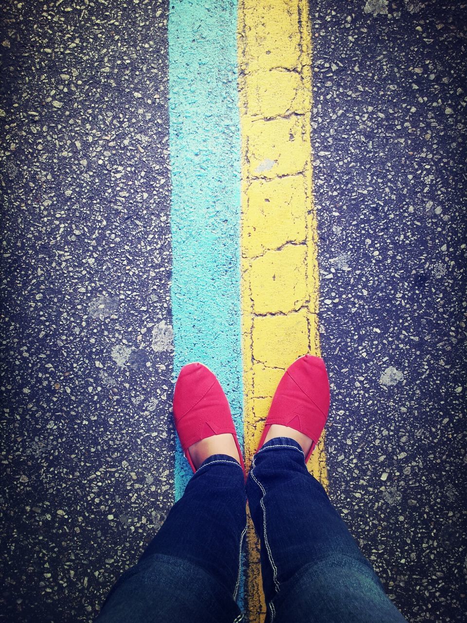 low section, person, shoe, personal perspective, standing, lifestyles, jeans, street, human foot, men, footwear, high angle view, road, leisure activity, unrecognizable person, part of, road marking