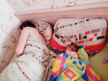 High angle view of father with daughter sleeping on bed at home