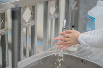 Midsection of woman holding hands in water