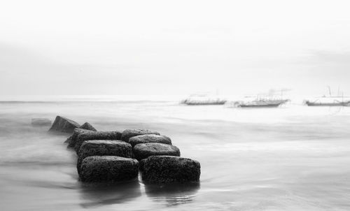 Rocks in sea against sky