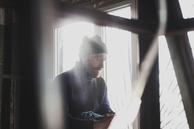 Man looking through window