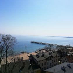 High angle view of buildings by sea against clear sky