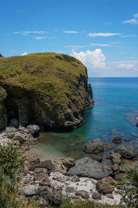 Rock formations by sea against sky