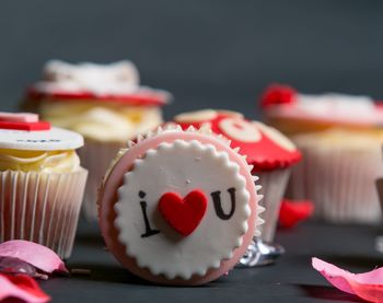 Close-up of cupcakes with text and heart shape on table