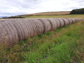 Hay bales on field against sky