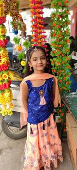 Portrait of cute girl standing by flowering plants