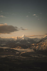 Scenic view of snowcapped mountains against sky during sunset