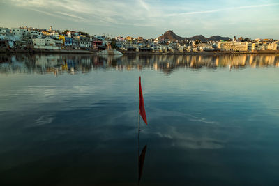 Scenic view of lake by buildings against sky