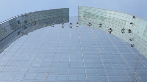 Low angle view of window washers on modern building