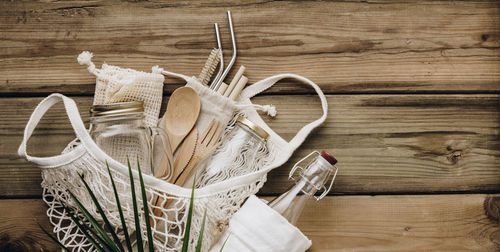 Directly above shot of bag with container and eating utensils on table