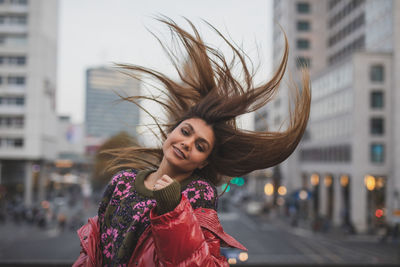 Portrait of smiling young woman in city