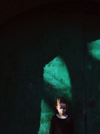View of young girl against green wall