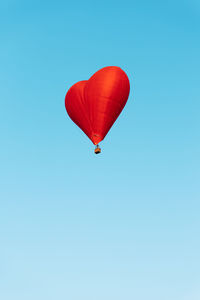 Low angle view of hot air balloons against clear blue sky