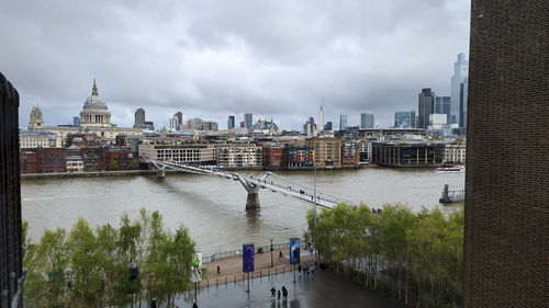Bridge over river against cloudy sky