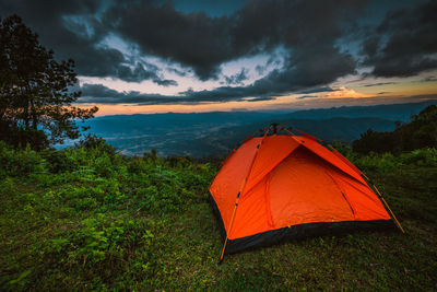 Tent on field against sky during sunset