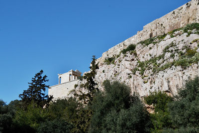 Low angle view of fort on mountain against clear blue sky