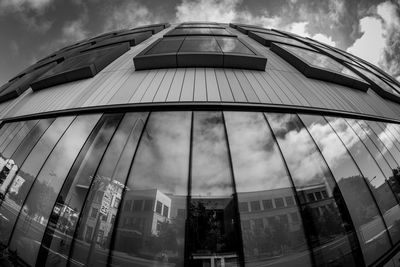 Low angle view of modern building against cloudy sky