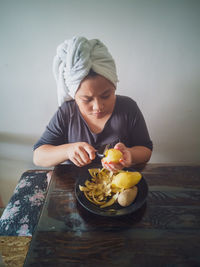 A young girl is peeling the potatoes. preparing cooking ingredients at home.