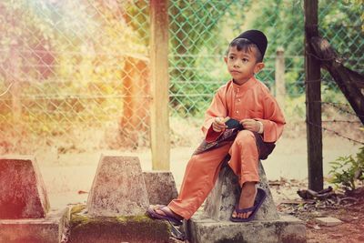 Rear view of boy looking at fence