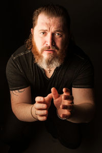 Portrait of man standing against black background