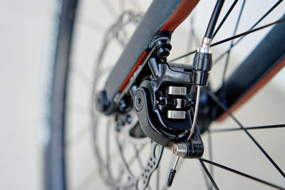 Part of the bicycle's braking system. grey metal brake disc and brake pads on road bike, close up.