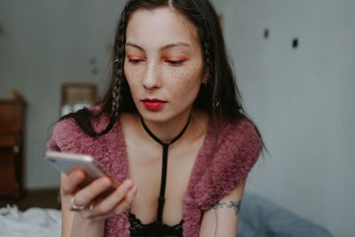 Sad woman with smartphone at home