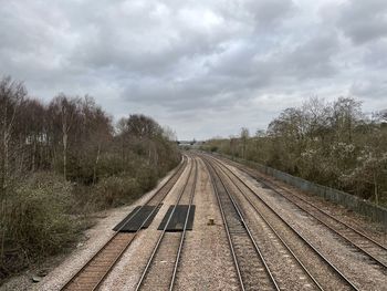 Railroad tracks amidst trees against sky