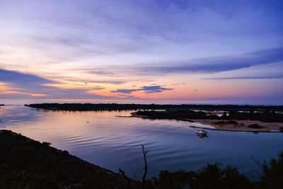 Boats in sea at sunset