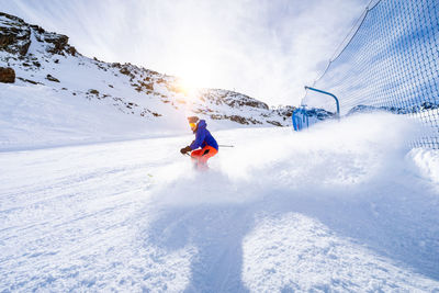 Man skiing on snowcapped mountain against sky