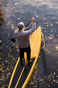 Man rowing paddle board in water, elevated view