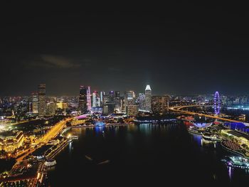 Illuminated buildings in city against sky at night