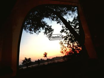 Low angle view of road sign against sky during sunset