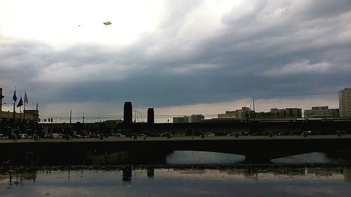 Bridge over river against cloudy sky