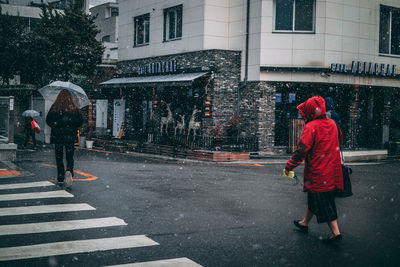 People walking on wet street in rainy season