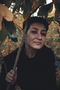 Portrait of woman holding leaves outdoors