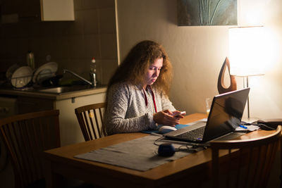 Woman sitting on table at home