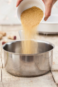 Close-up of hand pouring coffee cup