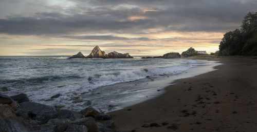 Scenic view of beach against sky during sunset