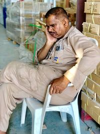 Man sleeping while sitting on chair