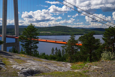 Overhead cable car over railroad track against sky