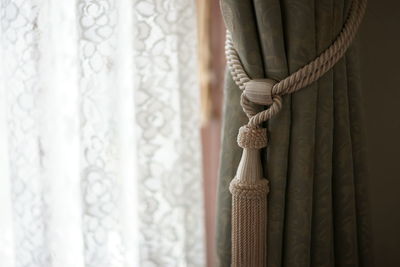 Curtain with tassel hanging at home