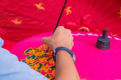 Midsection of man holding pink petals