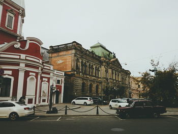 Cars parked in front of church against sky