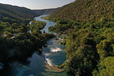 High angle view of river amidst trees against sky