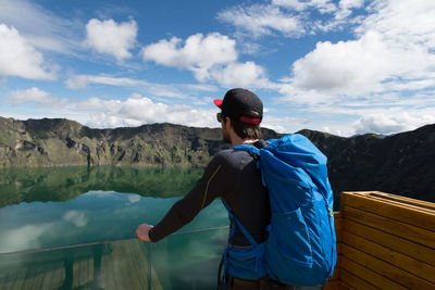 Man looking at lake by mountains