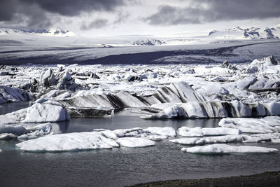 Snow covered mountain against cloudy sky