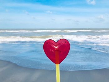 Heart shape on beach against sky