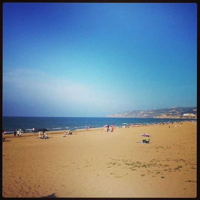 sea, beach, water, horizon over water, sand, transfer print, shore, clear sky, copy space, scenics, tranquil scene, blue, auto post production filter, tranquility, beauty in nature, large group of people, nature, vacations, sky, coastline