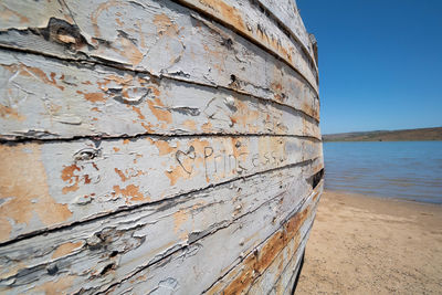 Close-up of rusty metallic structure on sea against sky
